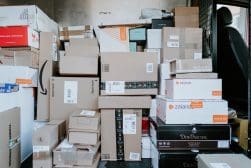 Many boxes are piled up in the back of a truck.