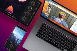 A laptop, phone, tablet, and camera are arranged on a colorful background.
