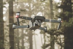 drone flying in air with trees in background