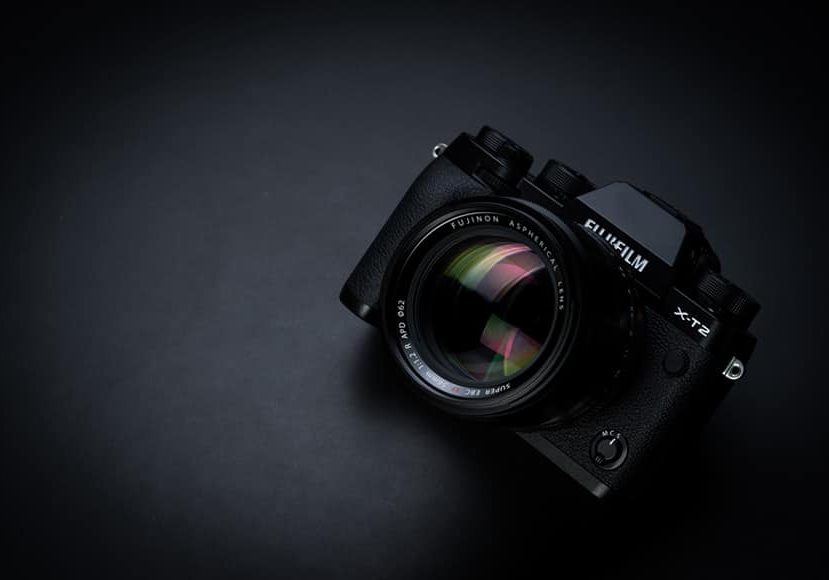The fujifilm x-e1 camera on a black background.
