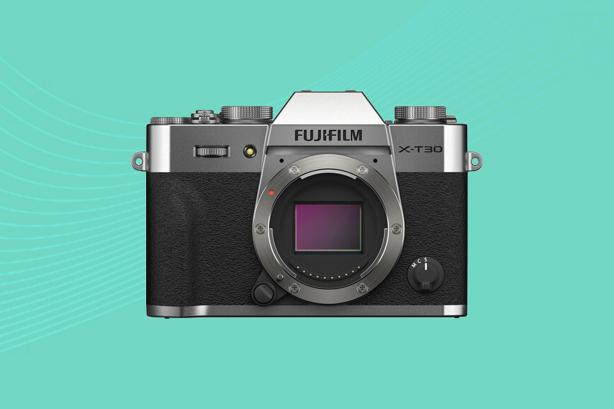 The fujifilm x100t camera on a turquoise background.
