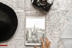 a woman holding an ipad on top of a map.